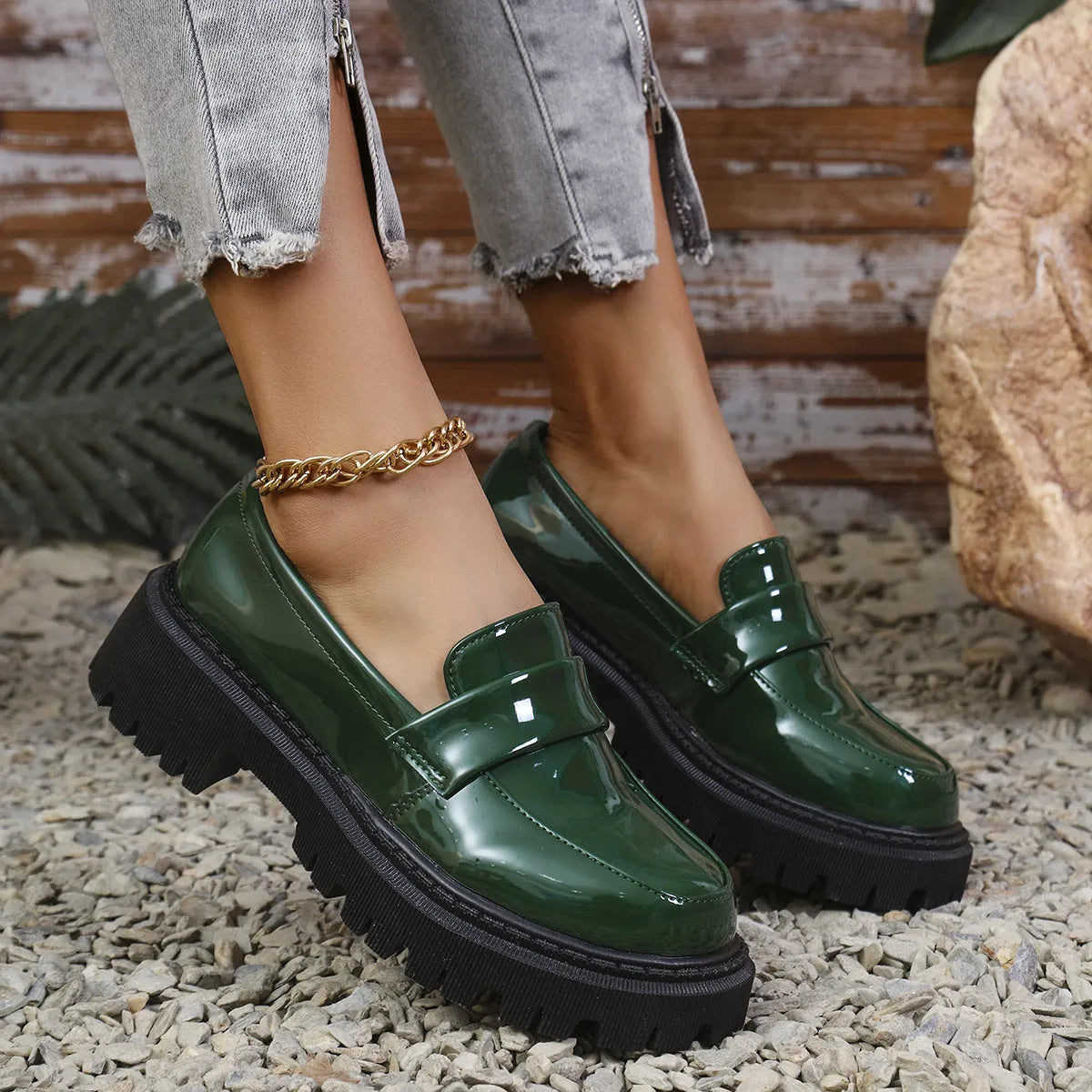 A pair of black plus size slip-on loafers with a chunky mid-heel and thick rubber sole on a plain background.