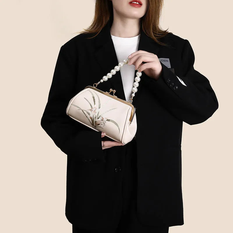 Beige women's embroidered shoulder bag with shell shape design made from soft PU leather