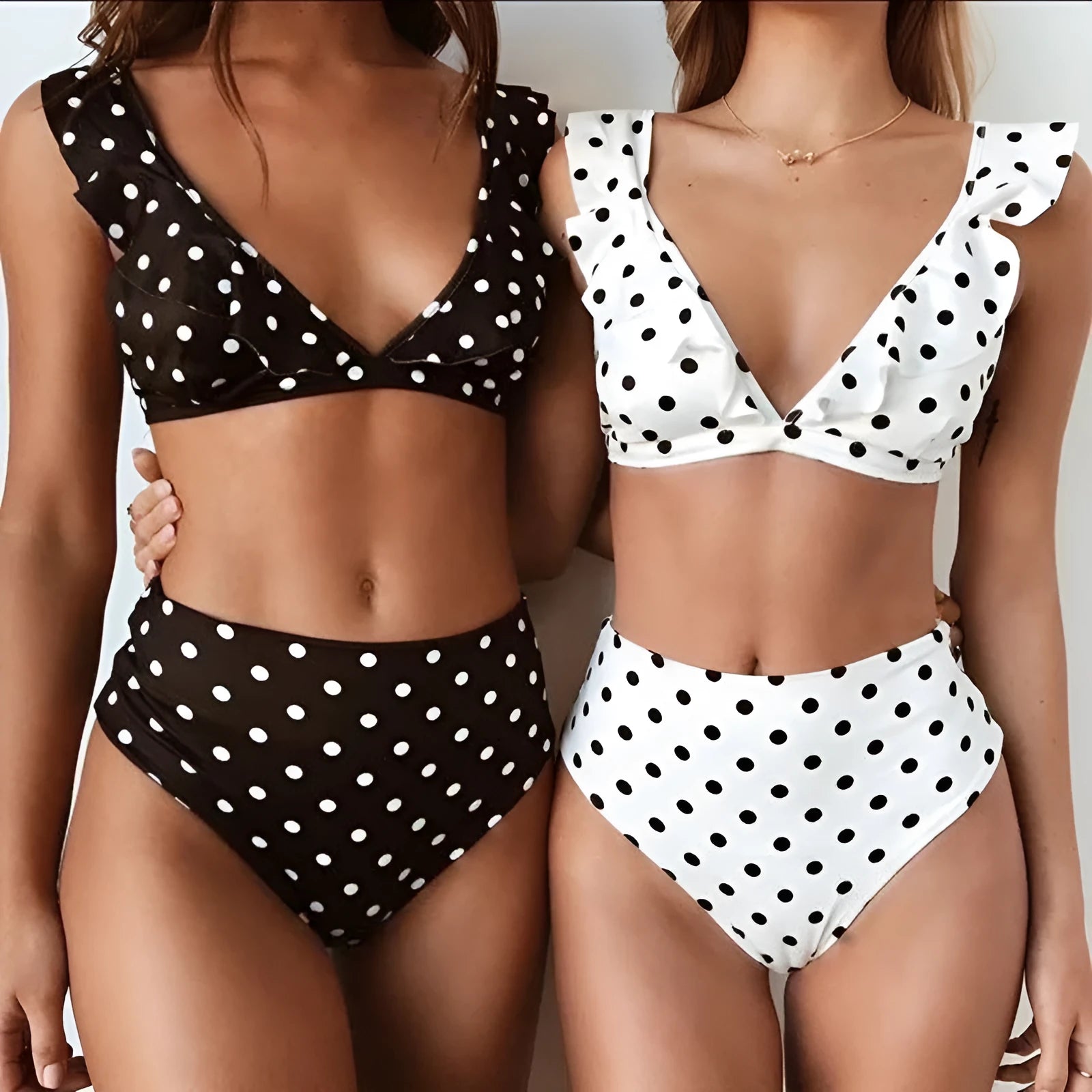 Women's black and white polka dot bikini set with ruffled deep V-neck top and matching shorts