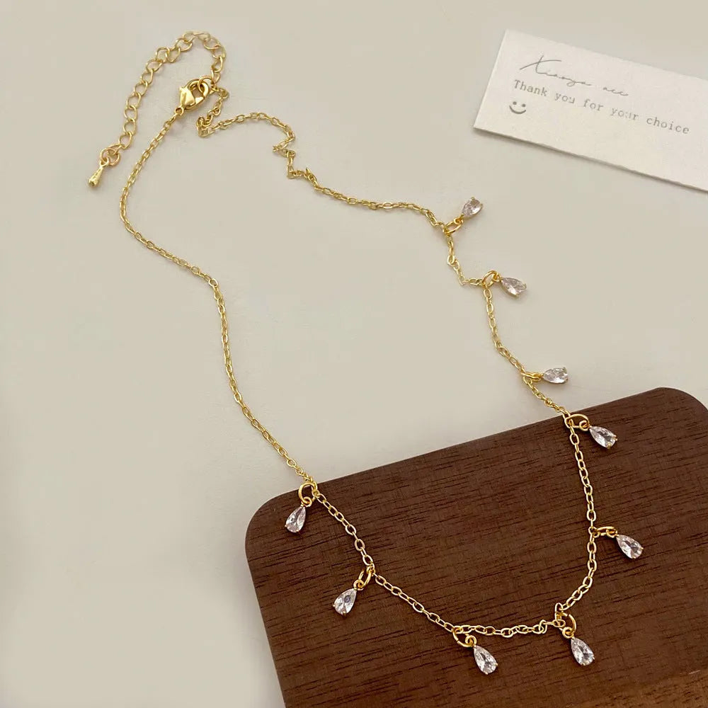 Women's zircon necklace, earrings, and anklet set with geometric pendant and meteor shower design.