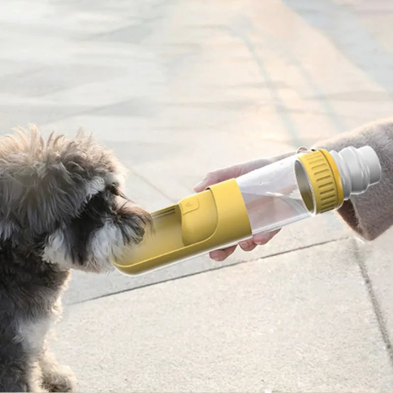 Dark blue portable dog water bottle with an attached drinking bowl, held in hand.
