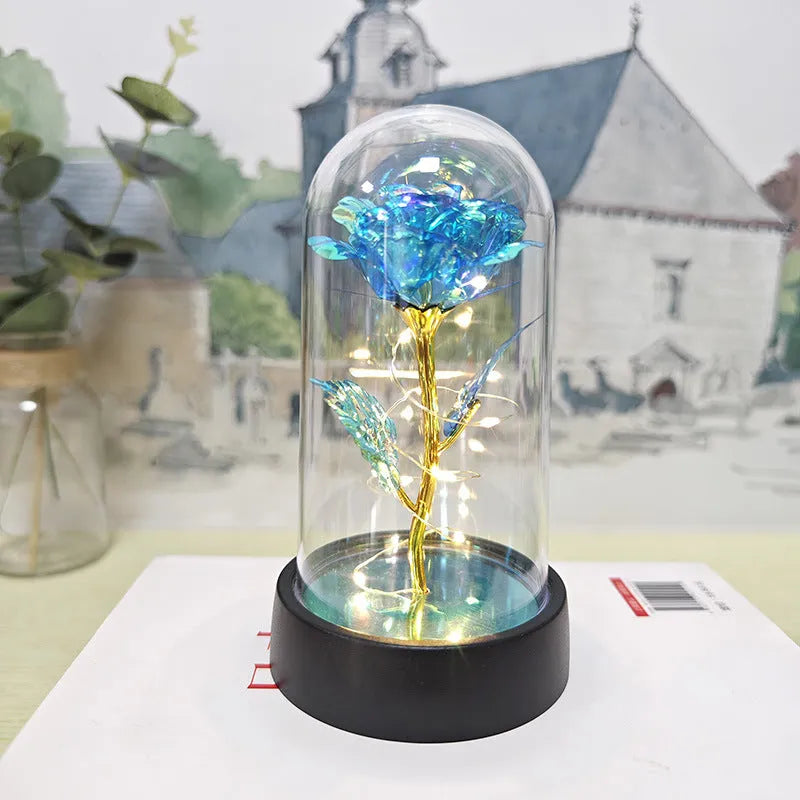 Small decorative night lamp with plastic flowers and a glass-style cover on a black base.