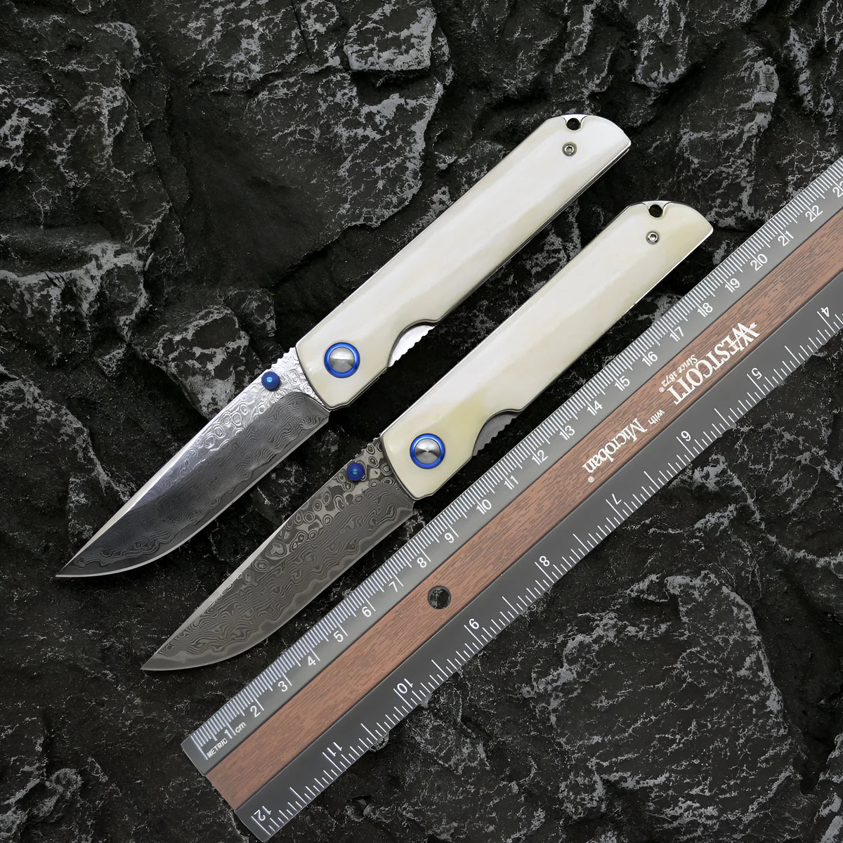 Damascus steel folding knife with black finish and ox bone handle, blade open showing 8.5cm cutting edge