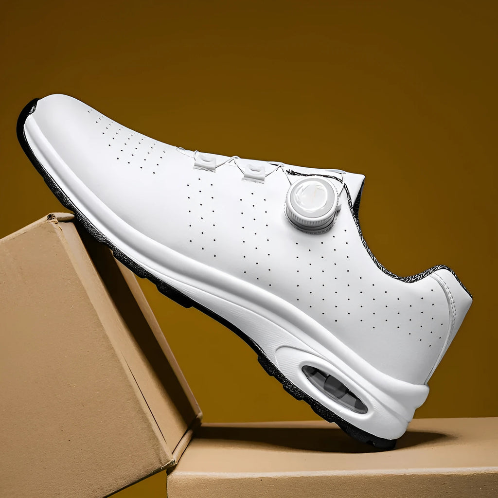 Black and white low-top tennis shoes with mesh upper and composite sole.