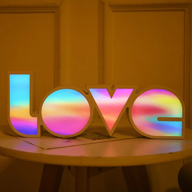 Rainbow style plastic LOVE LED decorative light on a surface.