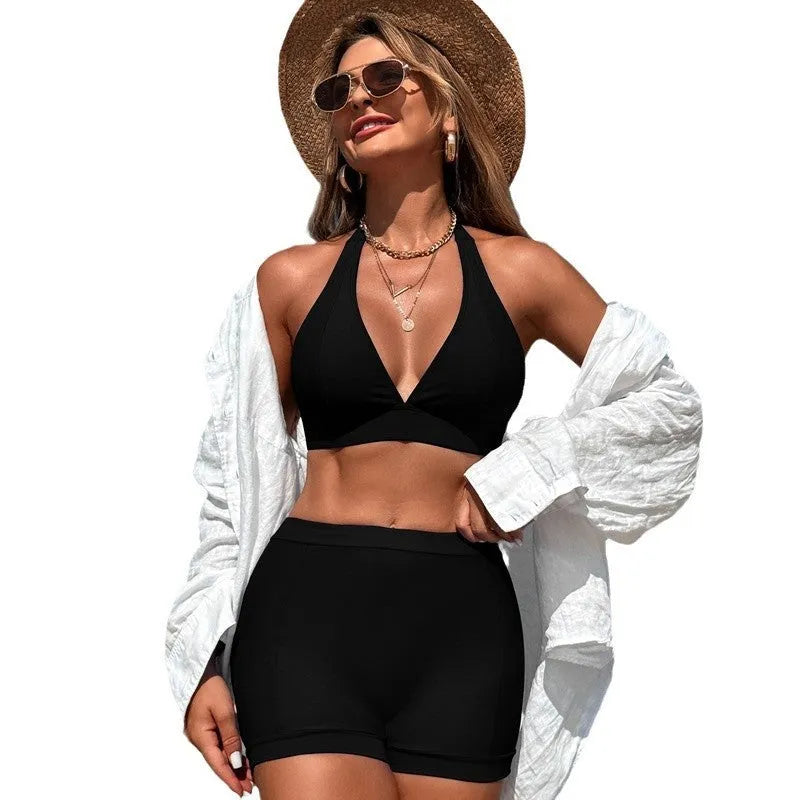 Women's black split bikini swimsuit laid flat, showing two-piece design.