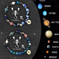 Two natural stone beaded bracelets with sterling silver zodiac charms on a wooden surface.