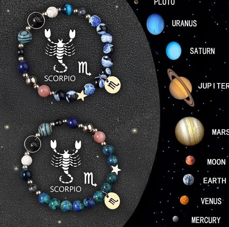 Two natural stone beaded bracelets with sterling silver zodiac charms on a wooden surface.