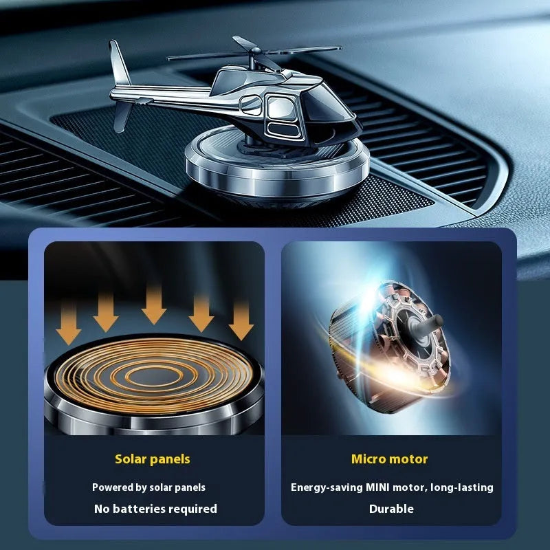 Silver metallic solar-powered helicopter car perfume ornament rotating on a car dashboard