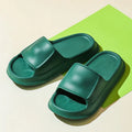 Pair of white EVA flip-flop slippers with a thick, textured sole on a tiled floor.