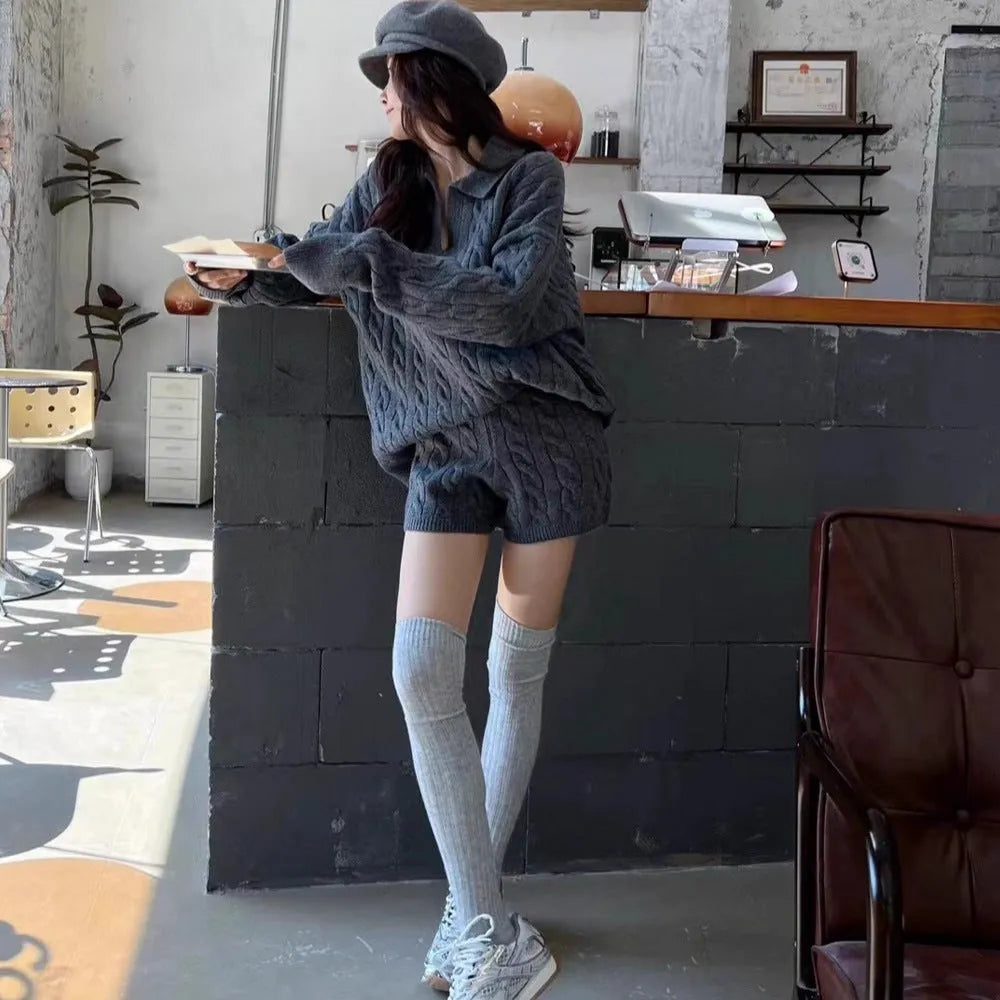 Women's creamy-white knitted suit set with geometric cable knit pattern, featuring a long sleeve top and elastic waist shorts.
