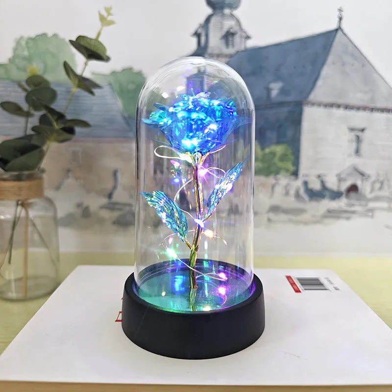 Small decorative night lamp with plastic flowers and a glass-style cover on a black base.