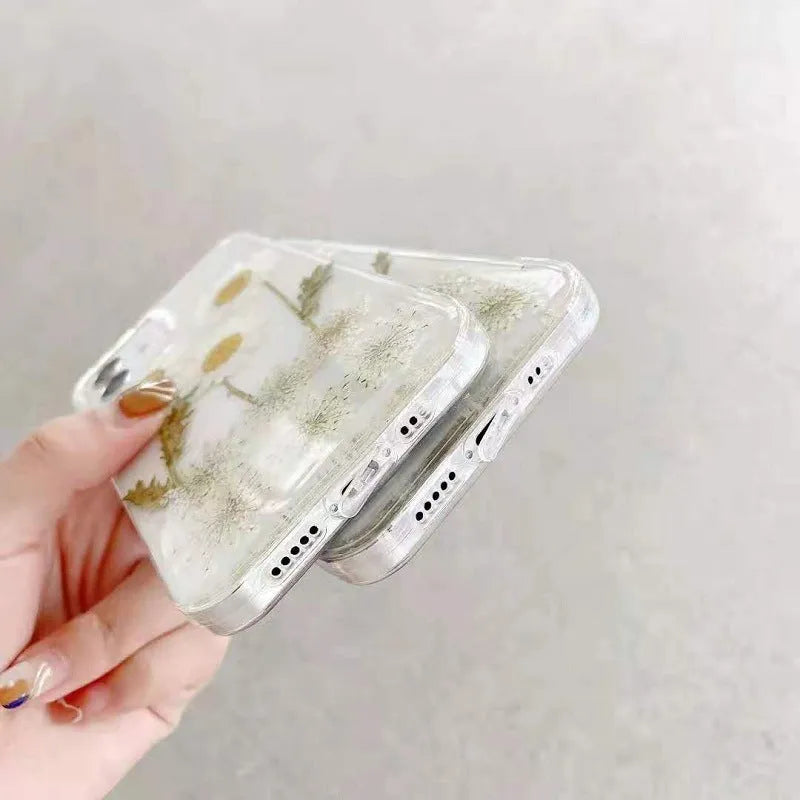 White iPhone case with a raised epoxy daisy floral pattern on the back.