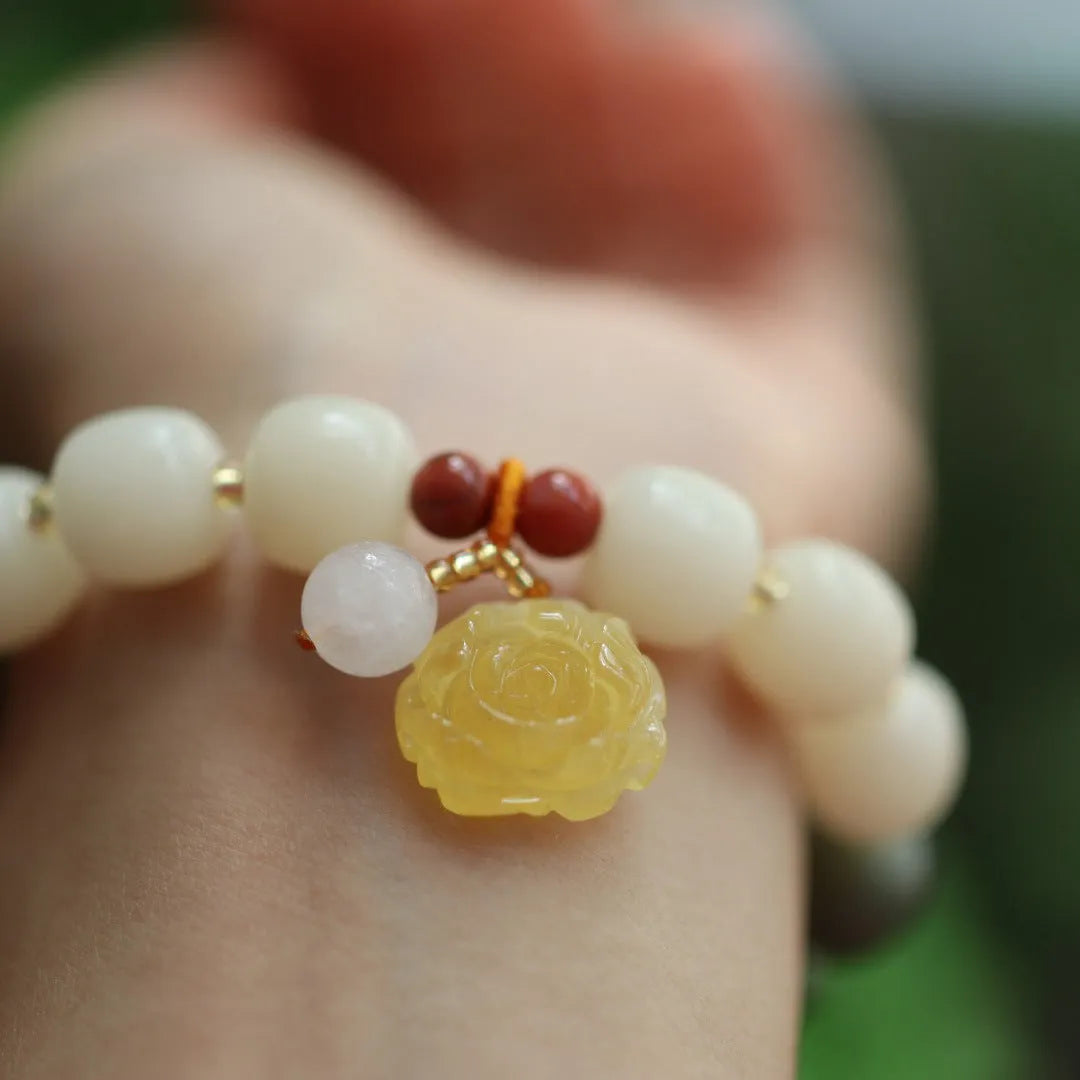 Women's Bodhi root bracelet with gradient white jade beads and a natural beeswax lotus pendant.