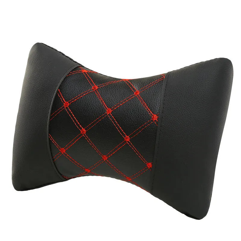Black quilted leather car headrest pillow with contrast stitching, shown on a car seat.