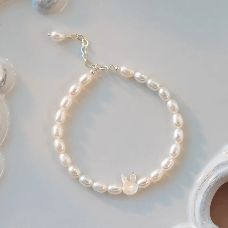 White shell bead bracelet with 925 silver rabbit charm on a black elastic string