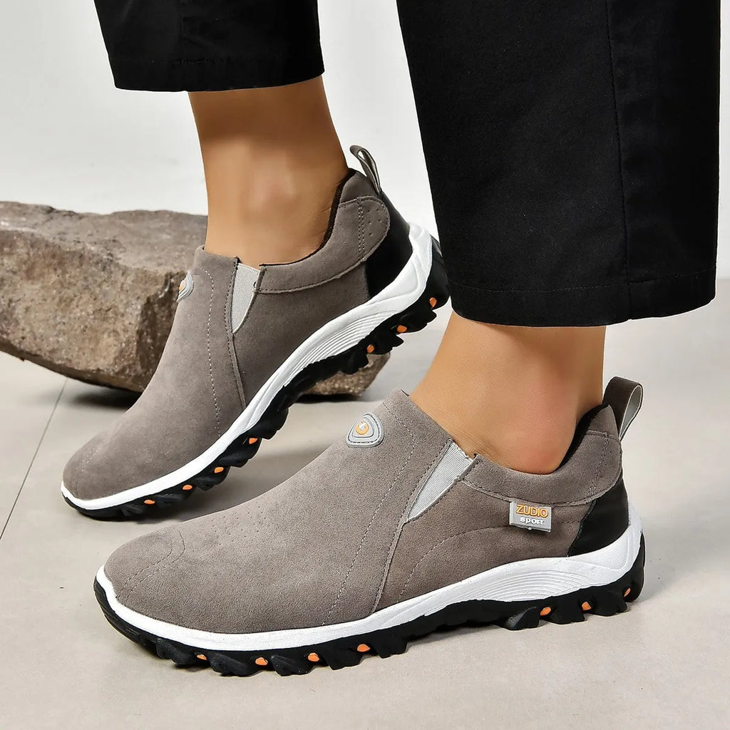 A pair of grey round-toe men's slip-on shoe covers made of PU with a rubber sole.