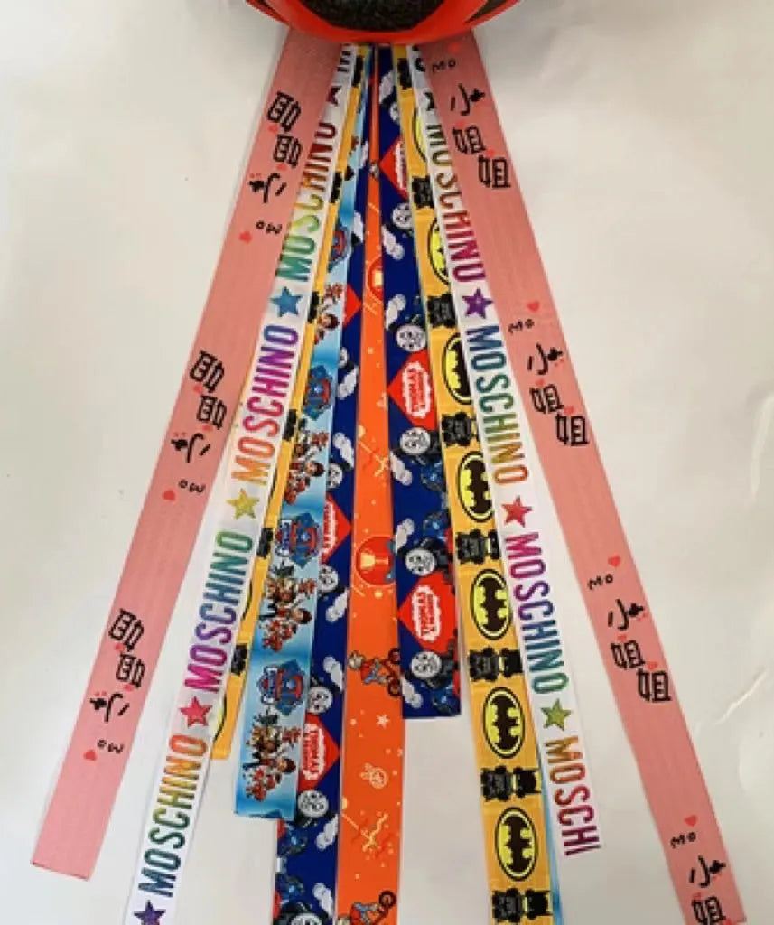 A decorative ribbon streamer for attaching to a child's roller skate or ski helmet, shown in a selection of colours.