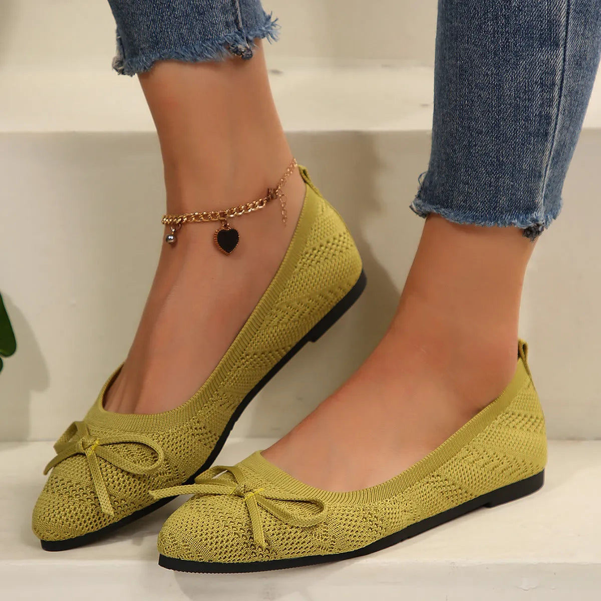 Women's blue knitted flat loafers with a pointed toe and a decorative bow on the front
