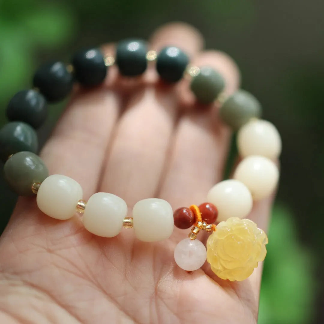 Women's Bodhi root bracelet with gradient white jade beads and a natural beeswax lotus pendant.