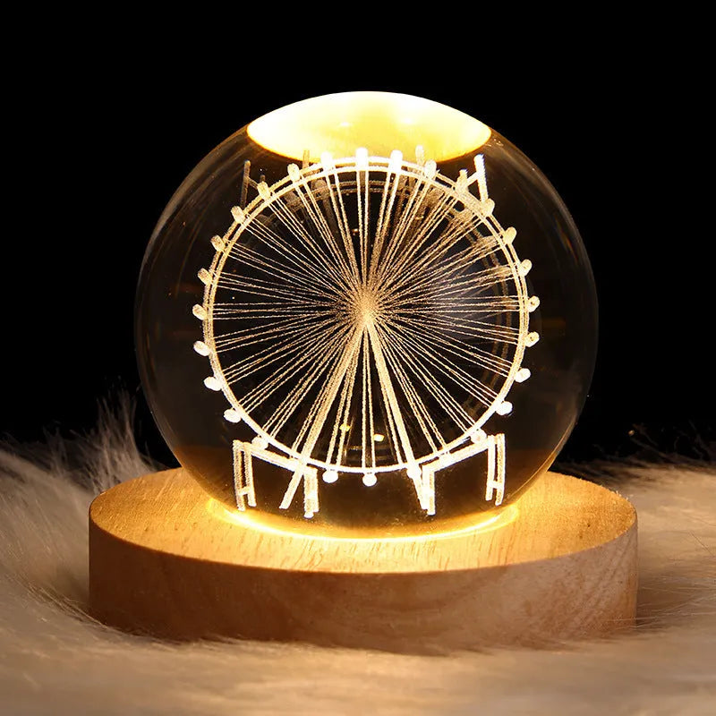 Clear crystal ball LED night light showing a 3D galaxy or planet design, lit from within on a table.