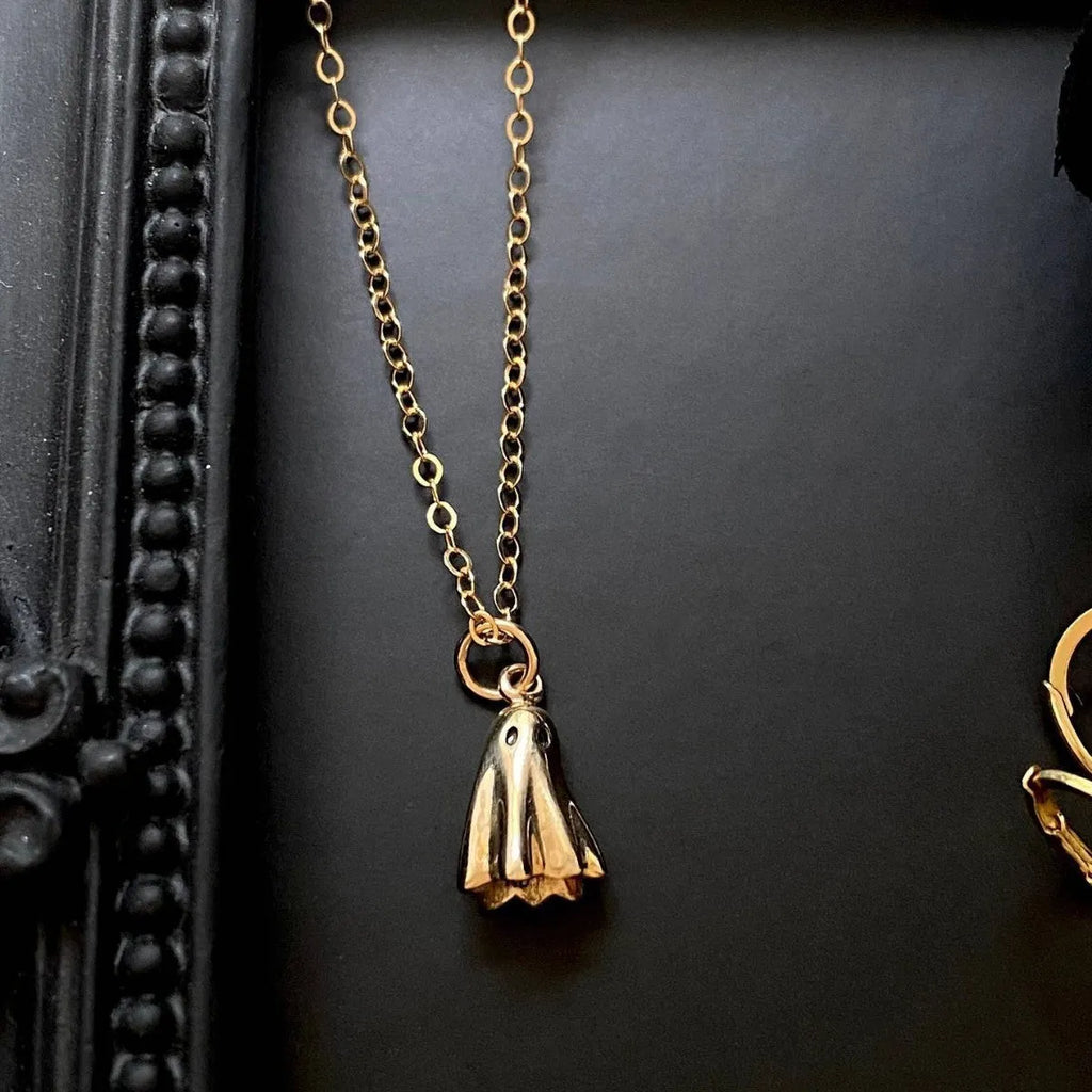 Ghost pendant necklace with twisted stainless steel chain on a person.