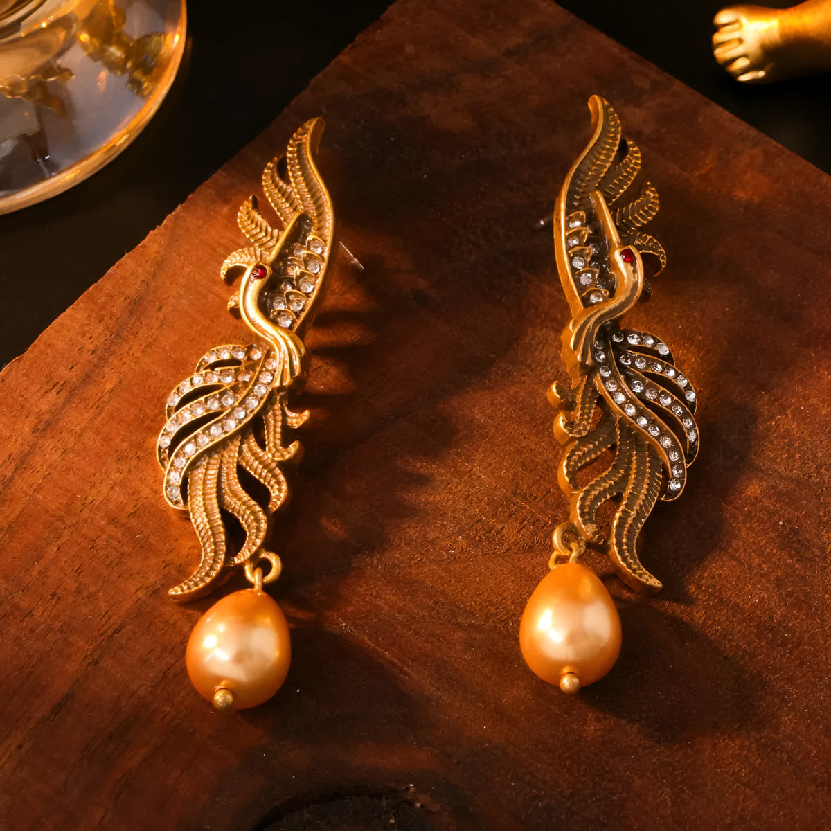 Pair of phoenix drop earrings in gold-tone electroplated alloy, hollow jeweled distressed design, 7cm by 1.6cm.