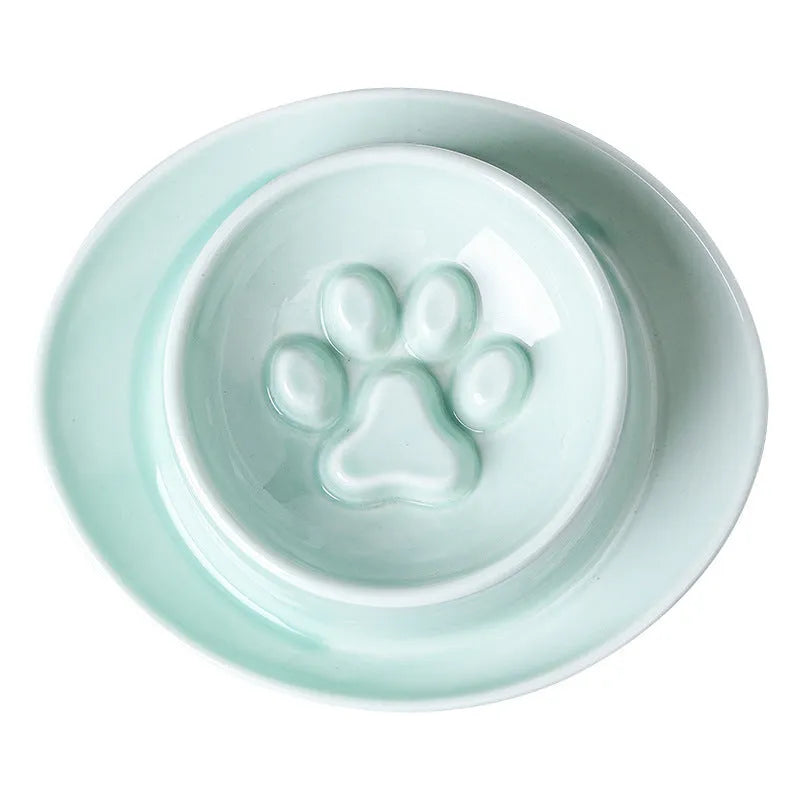 Green ceramic anti-choking slow food bowl for cats and dogs on a flat surface.