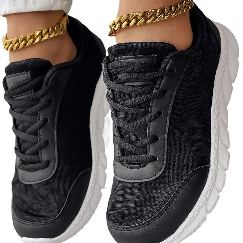 Women's white canvas running shoes with a flat heel and round toe on a plain background.