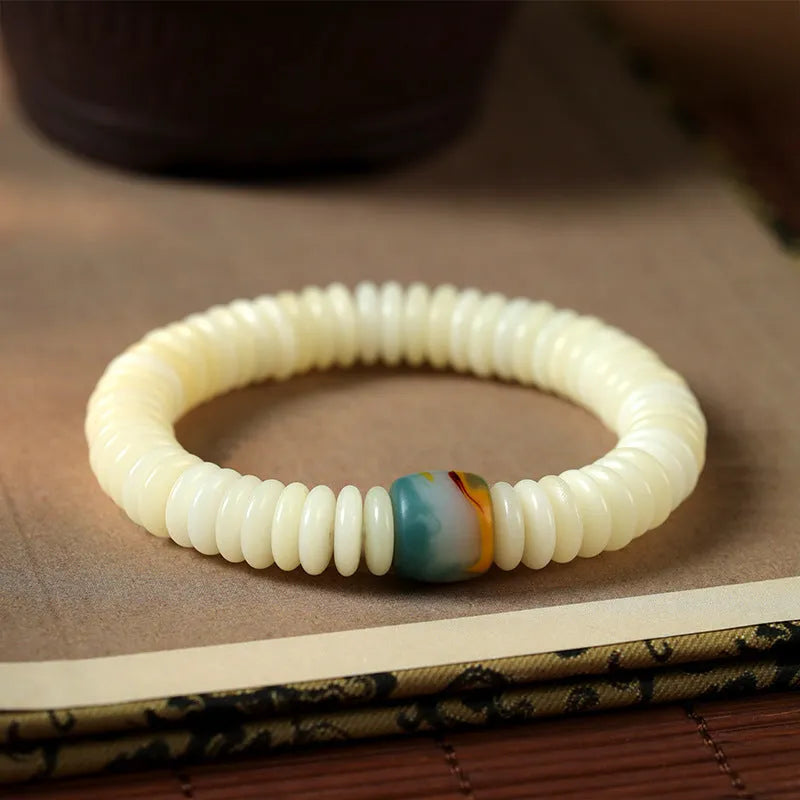 Close-up of a White Bodhi seed bracelet showing its 3x10mm beads and string.