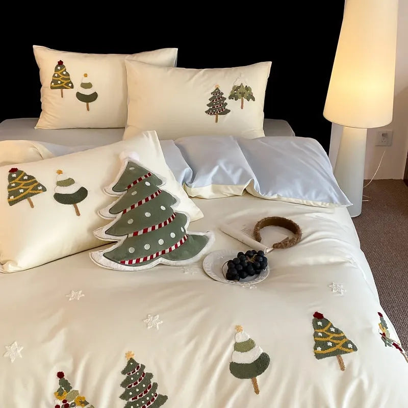 Cream blue cotton duvet cover with embroidered Christmas tree and floral design, laid on a bed with matching pillowcases.