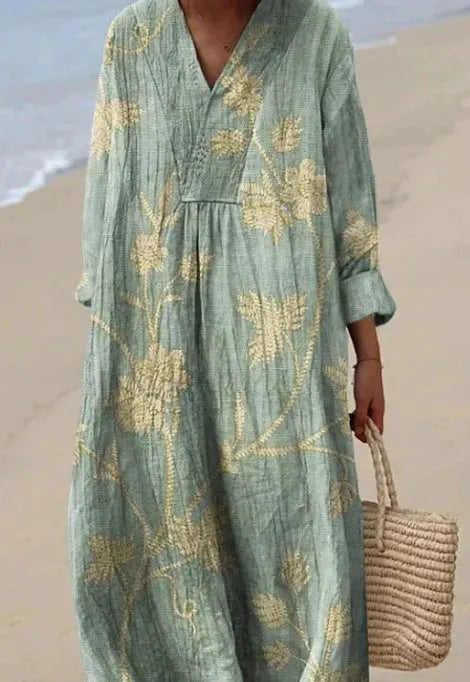 Long blue floral shirt dress with a 3D printed pattern, wide waist, and regular sleeves on a hanger.