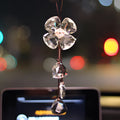 Crystal four leaf clover car pendant hanging, shown in one of four colour options: transparent, champagne, translucent black, or extremely shiny.