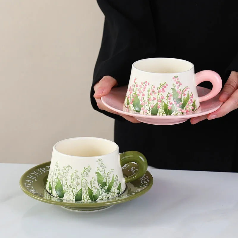 Ceramic coffee cup and saucer set with two cups, two plates, and two spoons