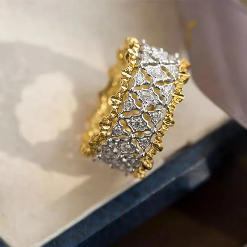 Geometric round two-tone gold and silver ring with a central zircon stone.