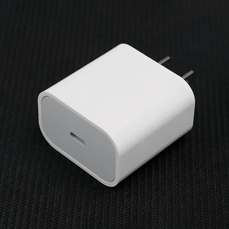 White USB mobile phone charger with detachable European and American plug heads on a grey background