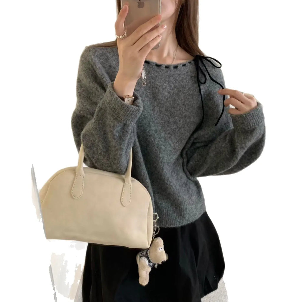A loose-fitting black women's knitted pullover on a hanger.