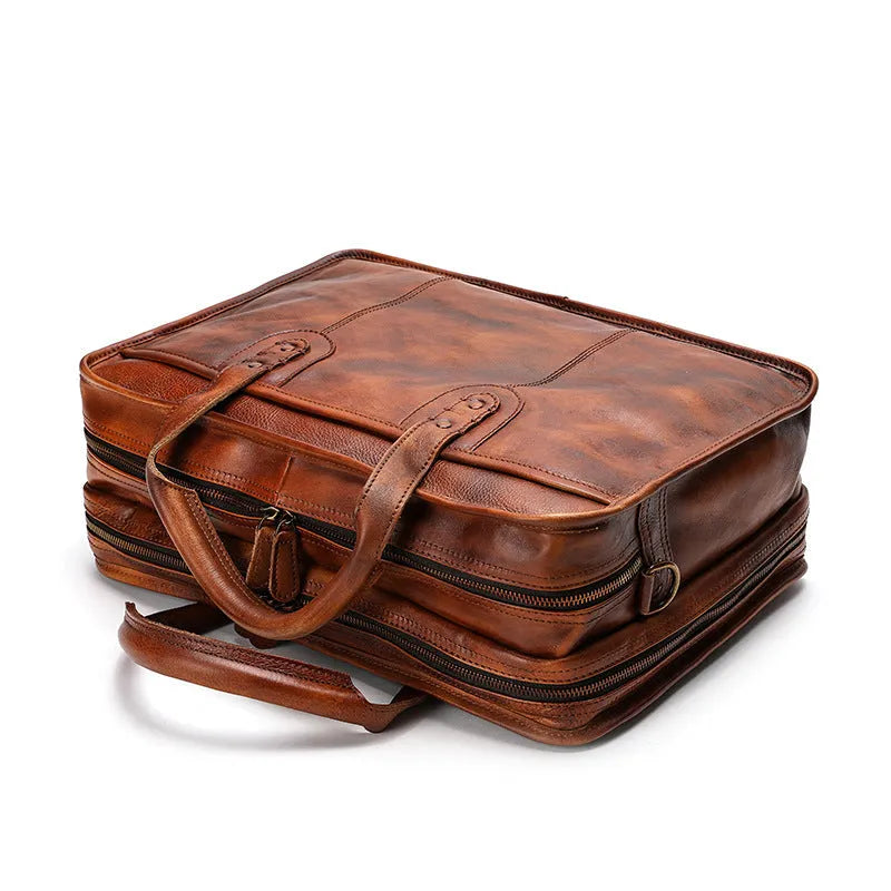 Brown vintage leather men's briefcase showing internal organiser pockets for laptop, documents, and phone.