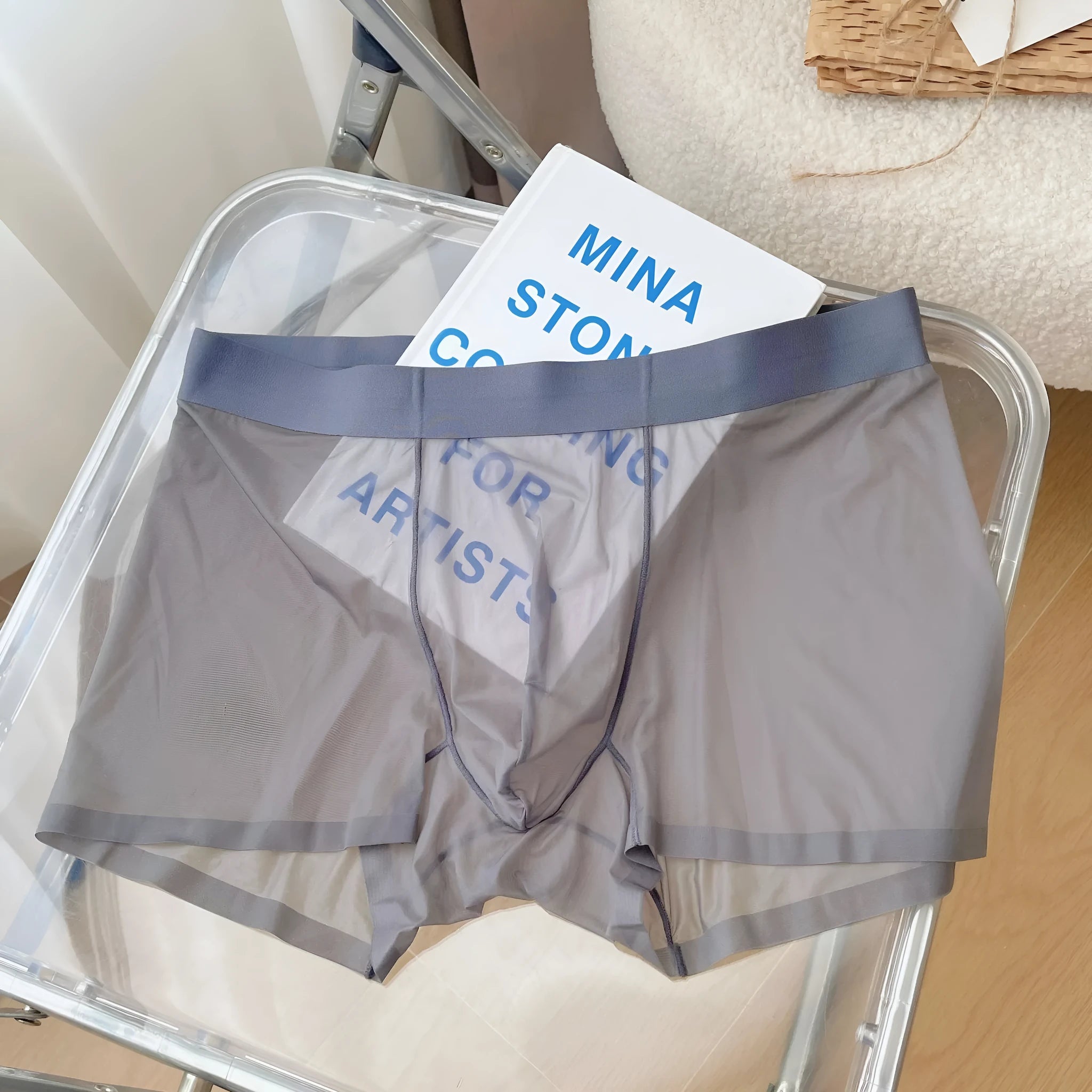 Man wearing thin grey seamless nylon boxer shorts with a mid-waist design.