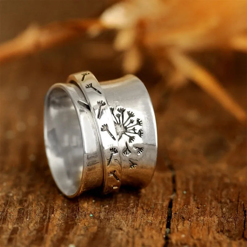 Silver-coloured rotatable flower fashion ring on a finger, showing the floral detail.