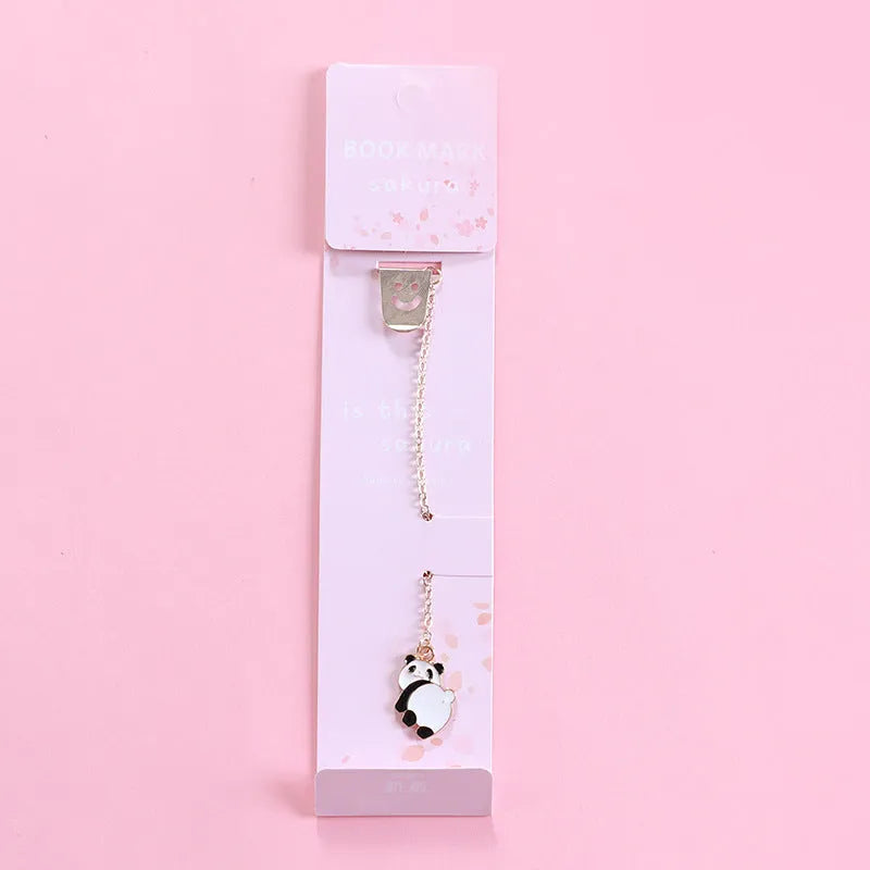Cartoon-themed alloy metal bookmark charm on a book page.
