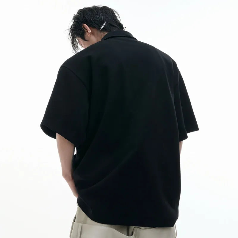 Men's black polo shirt with a deconstructed multi-collar design and geometric pattern detail.