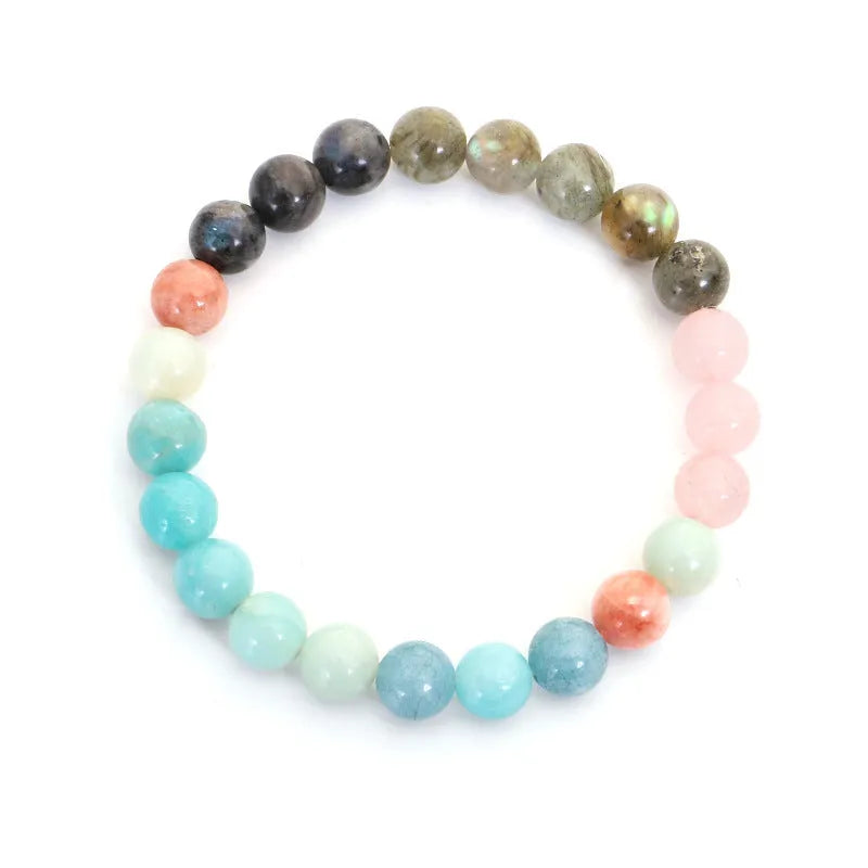 Bohemian style necklace and bracelet set with colourful drop-shaped stone pendants and tassel details on a white background