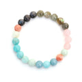 Bohemian style necklace and bracelet set with colourful drop-shaped stone pendants and tassel details on a white background