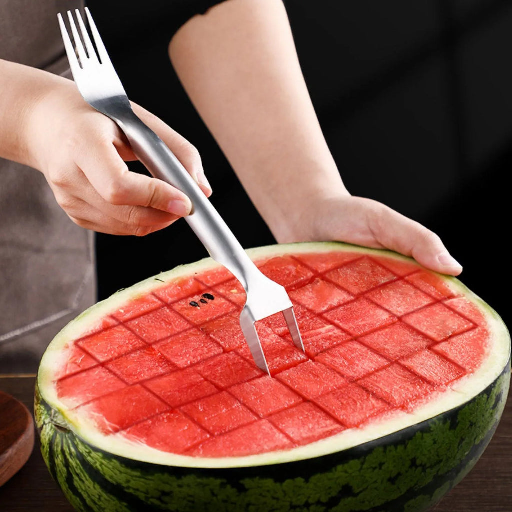 Stainless steel watermelon slicer and fork tool on a kitchen counter