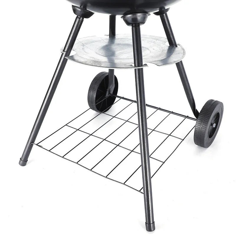 A portable 14-inch diameter iron barbecue grill with an Apple Stove design, shown on a garden patio.