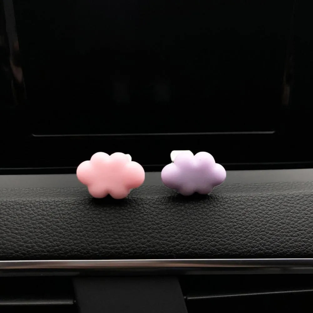 Resin cartoon-style car fragrance clip attached to a vehicle air vent.