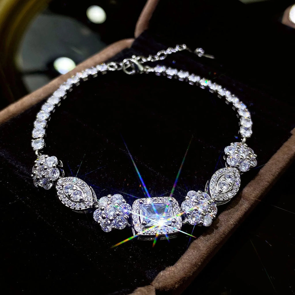 Close-up of a women's geometric silver bracelet with inlaid zircon stones on a wrist, showing adjustable chain.