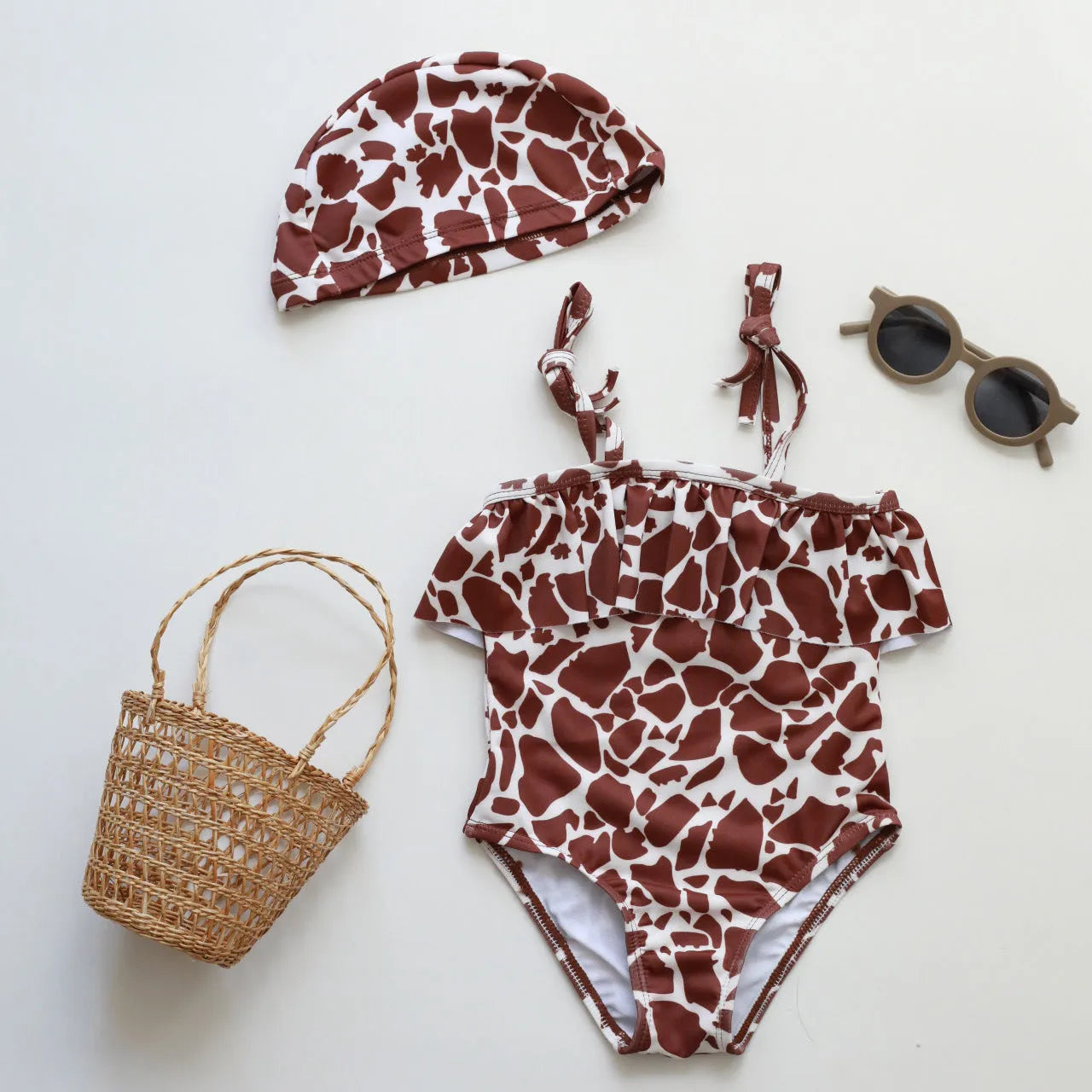 Girls' high elastic one-piece swimsuit in a selection of prints including brown stripes, leopard, and floral patterns.