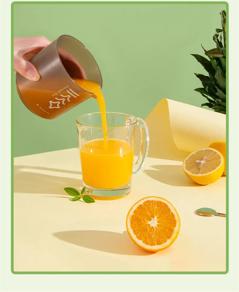 Green manual citrus juicer with white base on a kitchen counter.